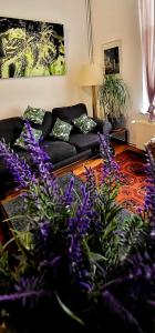 uma sala de estar com flores roxas e um sofá em Bright studio near Nato em Bruxelas