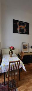stół jadalny z wazonem kwiatów w obiekcie Bright studio near Nato w Brukseli