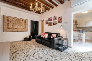 een woonkamer met een zwarte bank en een tafel bij Ponte Squero Flat M0270423226 in Venetië
