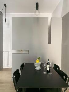 a black table with two wine glasses and a bowl of fruit at duo apartment in Salerno
