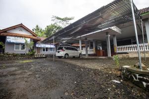 une voiture blanche garée devant un bâtiment dans l'établissement OYO Homes 91153 Desa Wisata Kawasen, à Padaherang
