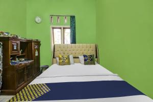 Säng eller sängar i ett rum på OYO Homes 91153 Desa Wisata Kawasen