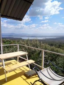 eine Bank und eine Hängematte auf einer Veranda mit Aussicht in der Unterkunft Lemon Valley Farm in Elmenteita