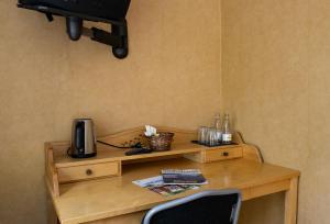 a wooden table with a tv on a wall at Christos Hotel in Söderhamn