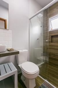 a bathroom with a toilet and a glass shower at Pousada Caminho Nômade in Imbituba +31 photos