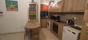 eine Küche mit Holzschränken und einer Arbeitsplatte in der Unterkunft Private Double Bedroom & private bathroom & shared kitchen in St Paul's Bay