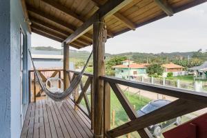 a porch with a hammock on a house at Pousada Caminho Nômade in Praia do Rosa