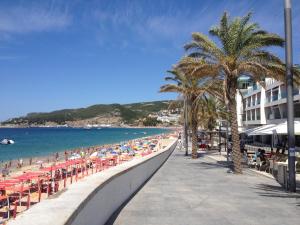 una playa con palmeras y gente en la playa en Beach4you - Sesimbra, en Sesimbra