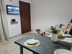 un soggiorno con tavolo e TV di Olivar Suites a Paleocastro (Palekastron)