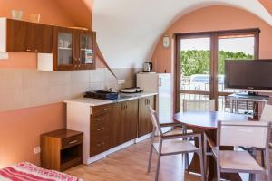 a kitchen with a table and a dining room at Willa Mila in Trzęsacz