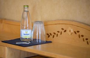 a bottle on a table next to a glass at Christos Hotel in Söderhamn