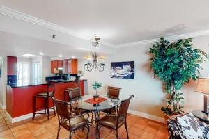 a dining room and kitchen with a table and chairs at Mainsail 244 in Destin