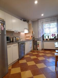 a kitchen with white cabinets and a checkered floor at EMAR in Karpacz