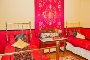 a red room with two beds and a table at The Duck House in Burnie