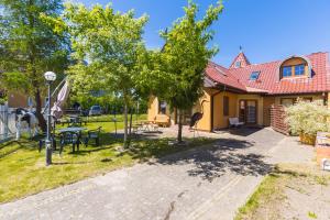 a house with a yard with tables and chairs at Willa Mila in Trzęsacz