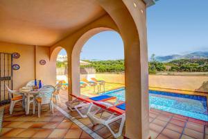 a patio with a table and chairs and a pool at Villa Reyes in Nerja