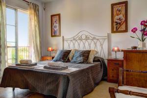 a bedroom with a large bed and a window at Villa Reyes in Nerja +10 photos