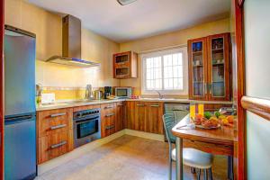 a kitchen with a table and a blue refrigerator at Villa Reyes in Nerja