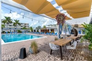 a patio with a table and chairs next to a pool at Updated WATERFRONT, pool, tiki bar, boat ramp, etc in Marathon