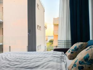 a bedroom with a bed and a large window at Relax Beach Apartman in Fonyód