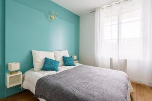 Ilbetea - Duplex tout confort - Plage à 400 m - Parking - Wifi في سان جان دو لوز: غرفة نوم زرقاء مع سرير كبير بجدران زرقاء