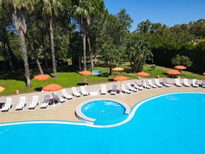 a pool with chairs and umbrellas and umbrellas at Futura Club La Praya in Pizzo