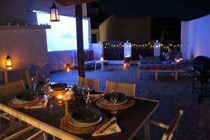 a table with plates and glasses on it in a living room at Spa, Sierra y sol in Cortes de la Frontera