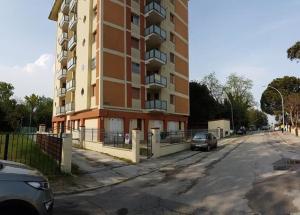 een groot appartementencomplex met een auto ernaast bij Sun Ste in Lido di Pomposa