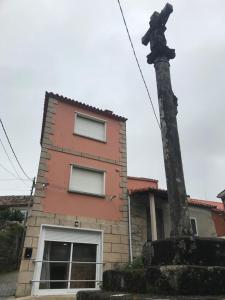 un edificio con una estatua delante de él en A Casa de Santos en Combarro
