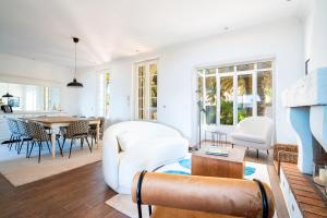 uma sala de estar com mobiliário branco e uma mesa em VILLA AMPHITRITE, SAINT TROPEZ em Saint-Tropez