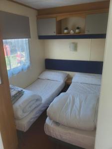 Llanddwyweにある92 Barmouth Bay Holiday Parkの窓付きの小さな部屋のツインベッド2台