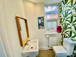 een badkamer met een wastafel, een toilet en een spiegel bij RELAX Blackpool in Blackpool