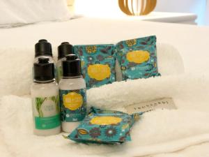 two bottles of hair products sitting on a bed at Guest House Guarujá Hotel Boutique in Guarujá