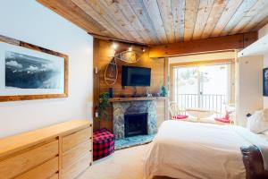 a bedroom with a bed and a fireplace at Moguls 813 in Big White