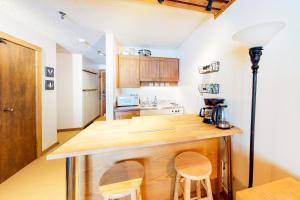 a kitchen with a wooden counter and two chairs at Moguls 813 in Big White