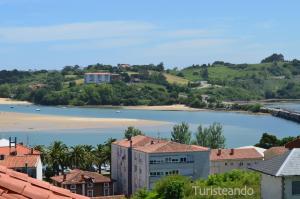 einen Blick auf eine Wasserfläche mit einem Strand in der Unterkunft Rincón del Cantábrico: para amantes de las buenas vistas in San Vicente de la Barquera