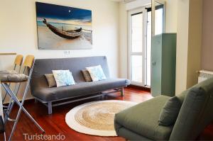 ein Wohnzimmer mit einer Couch und einem Sessel in der Unterkunft Rincón del Cantábrico: para amantes de las buenas vistas in San Vicente de la Barquera