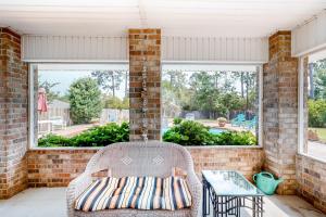 - une terrasse couverte avec une chaise en osier et une table dans l'établissement Emerald Coast Dream Haven, à Navarre