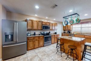a kitchen with wooden cabinets and stainless steel appliances at Emerald Coast Dream Haven in Navarre