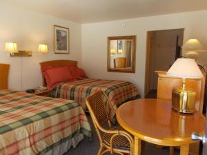 Habitación de hotel con 2 camas y mesa en Colusa Riverside Inn, en Colusa