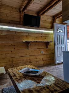 une pièce avec un mur en bois avec une table et une porte dans l'établissement Holiday vikendica, à Žabljak