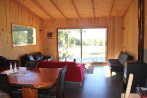 sala de estar con mesa y ventana grande en Casa de Campo Buenavista, en Pucón