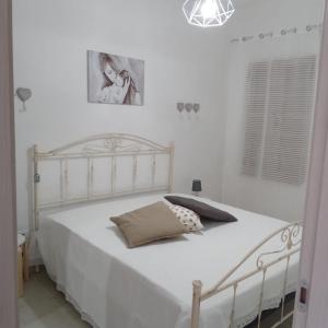 1 dormitorio con cama blanca y colcha blanca en Casa Angelina Summer, en Casalabate