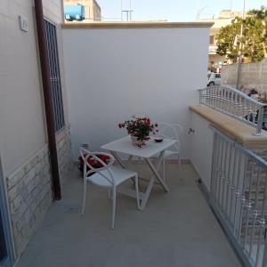 una pequeña mesa blanca y sillas en el balcón en Casa Angelina Summer, en Casalabate