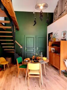 een eetkamer met groene muren en een tafel en stoelen bij Le Petit Bégou in Saint-Auban-dʼOze
