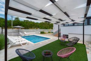 un patio con piscina y sillas y una piscina en Luxury with gallery, heated pool only for you-KLIS CRO, en Klis