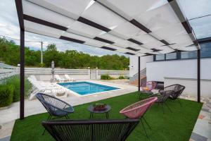 un patio con sillas y una piscina en Luxury with gallery, heated pool only for you-KLIS CRO, en Klis