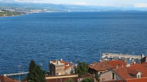 a view of a large body of water with buildings at Apartments Komel II in Opatija