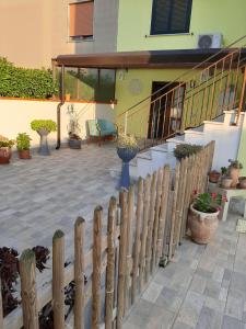 una valla de madera frente a una casa con plantas en Casa Vilu' en Paestum