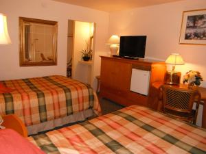 a hotel room with two beds and a television at Colusa Riverside Inn in Colusa